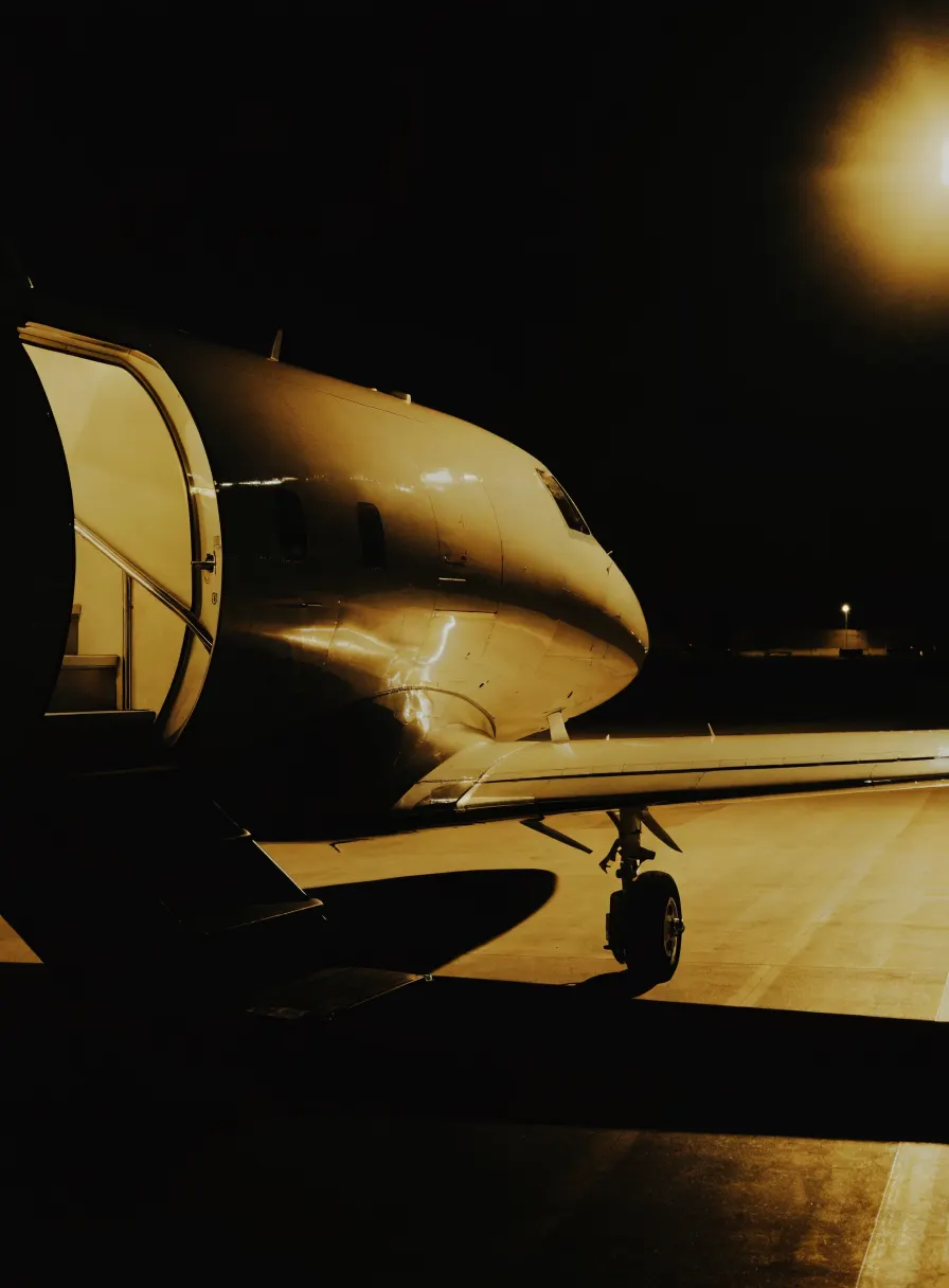Private jet on a floodlit apron at night